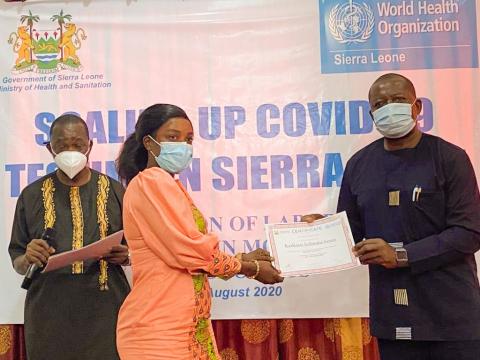 A trainee molecular lab technician receiving a certificate after two weeks intensive training