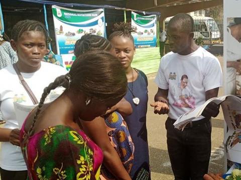 An attendant talks to visitors at the fair