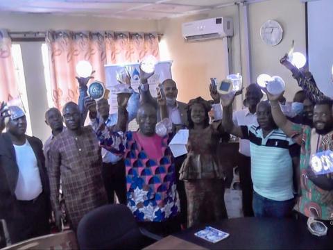 Deputy District Directors displaying solar lamps