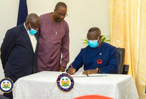 President Bio giving his assent as Minister of Information and Attorney General look on